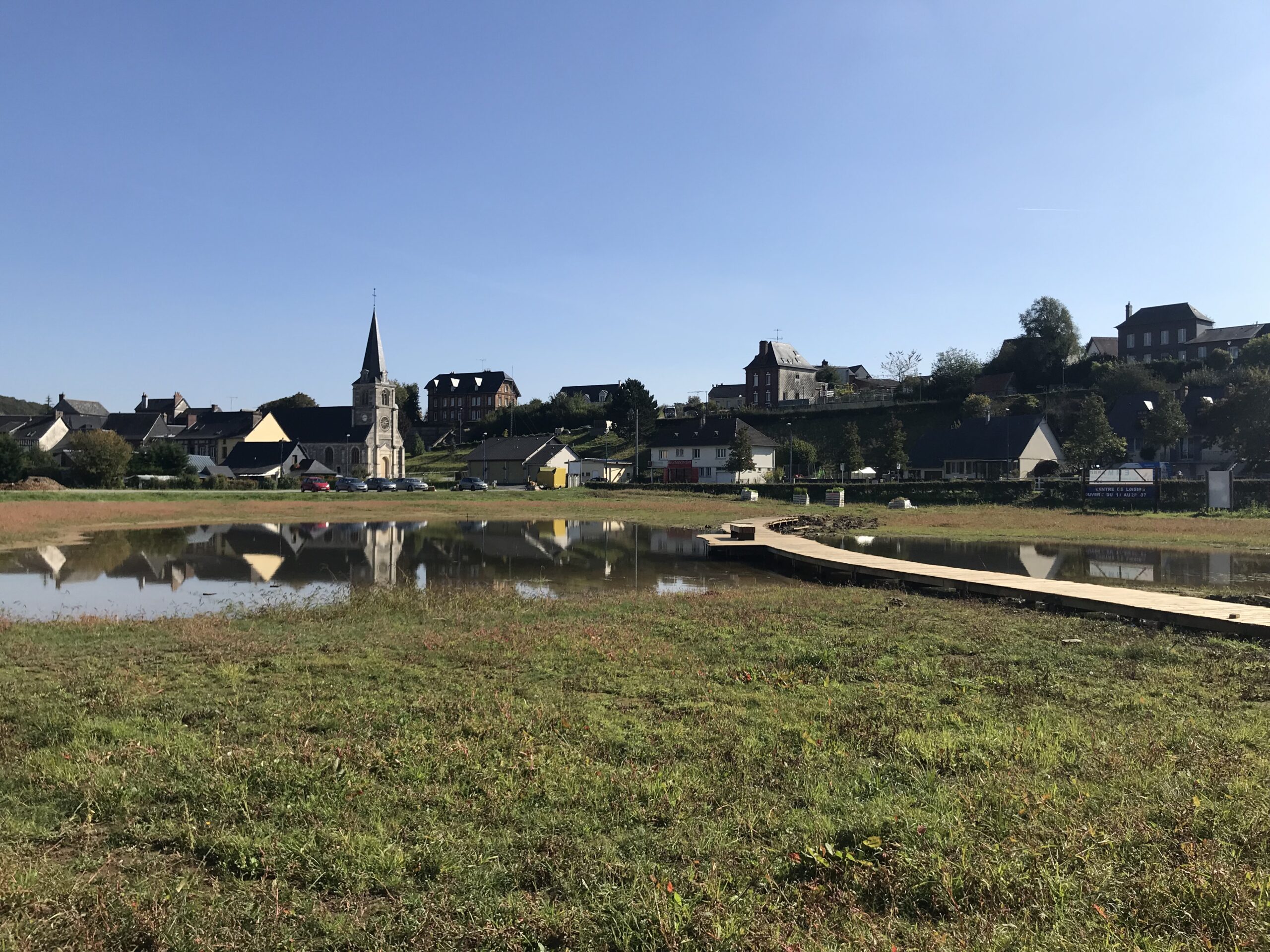 Plan d'eau avec en arrière plan un village et son église