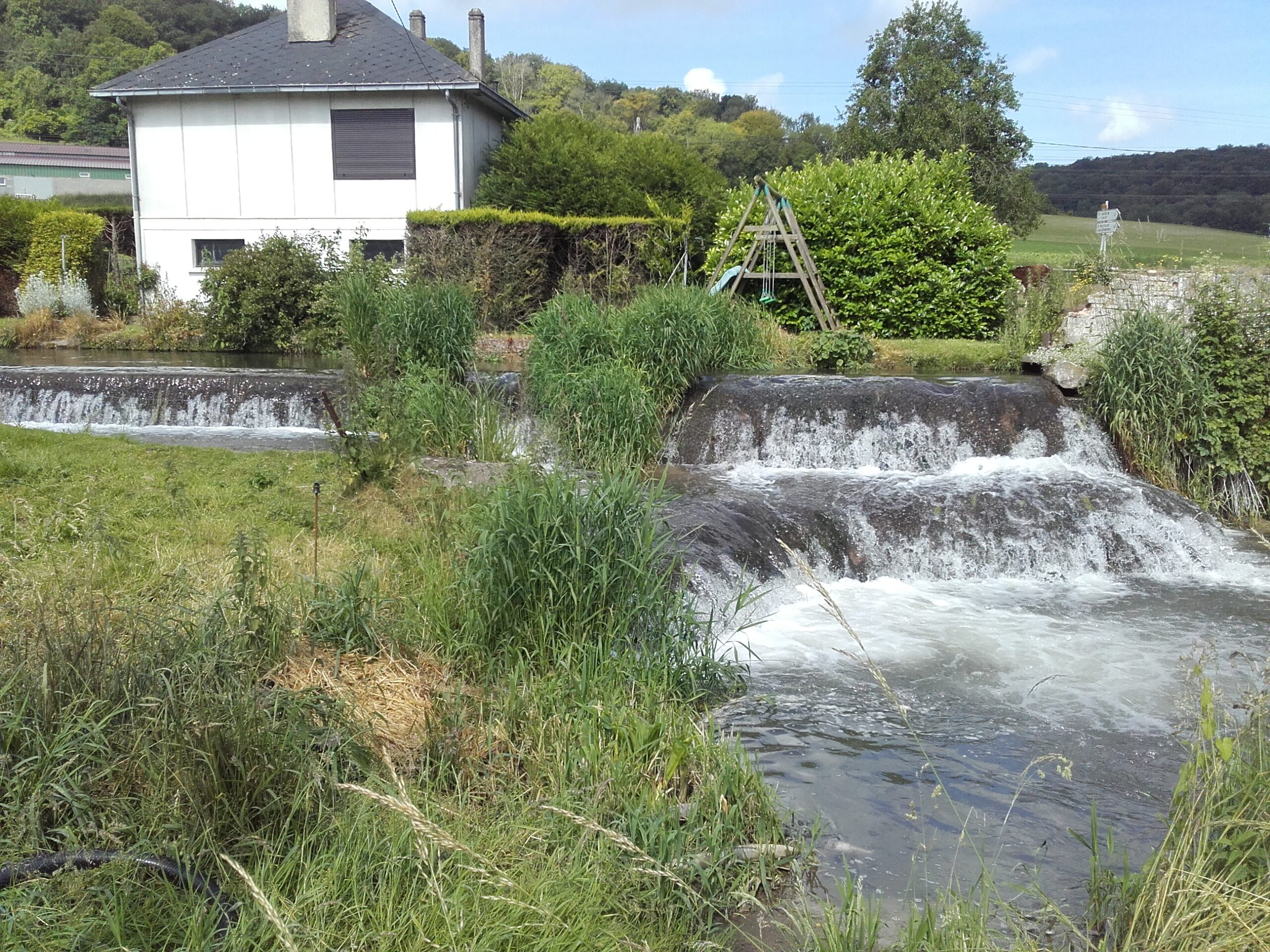 Chutes d'eau d'une rivière sur d'anciens ouvrages résiduels d'un moulin aujourd'hui disparu