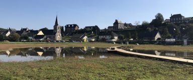 Plan d'eau avec en arrière plan un village et son église